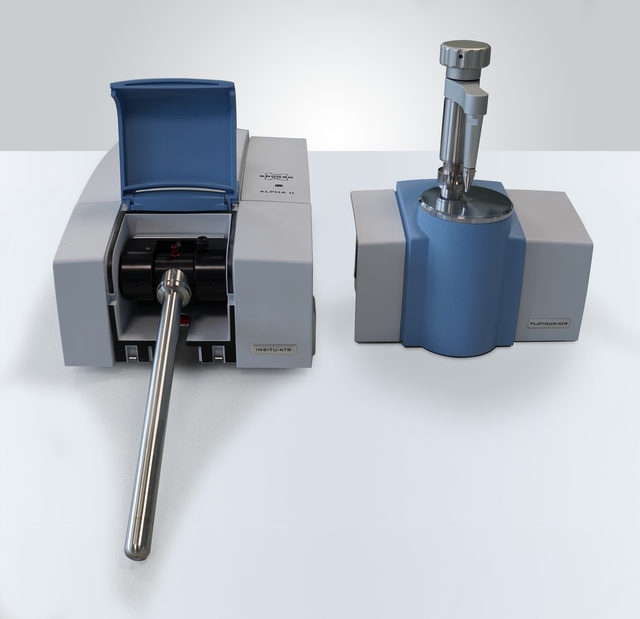 An ALPHA II with the INSITU-ATR module fitted, the stainless steel light pipe probe angled down out of the sample compartment, next to the Platinum ATR module it replaces